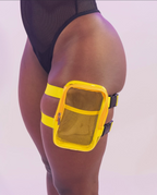 Transparent thigh bag with yellow mesh pocket worn by a person on a white background