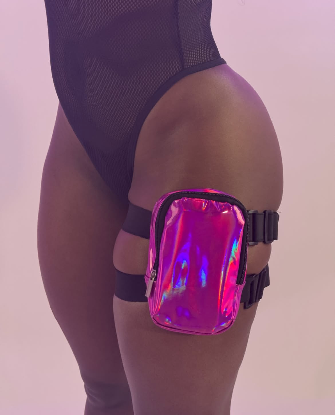 Holographic thigh bag worn by a person on a light purple background