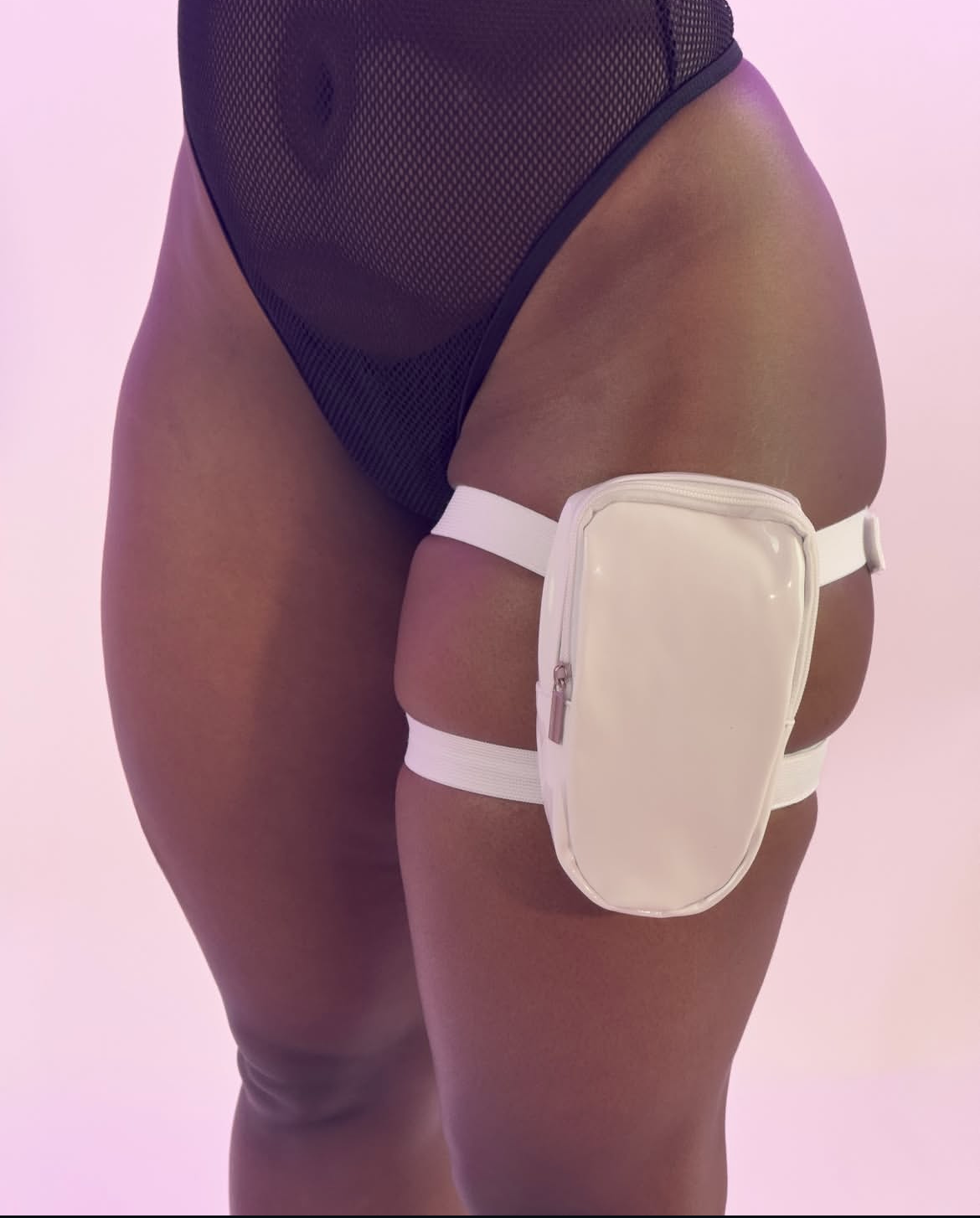 Holographic thigh bag worn by a model on a light pink background